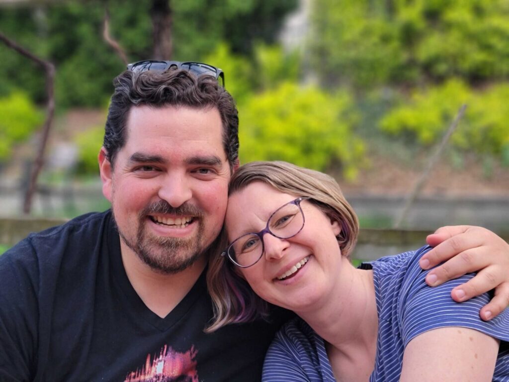 Rodrigo and his wife Linzy smiling warmly at the camera, with Linzy resting her head on his shoulder.